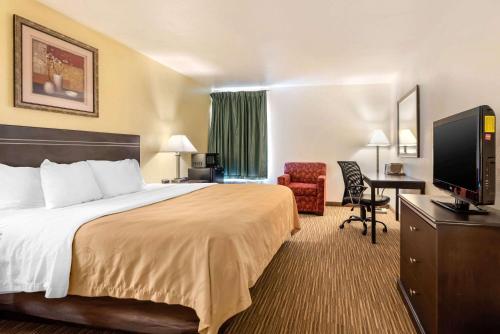 利蒙利蒙品质套房酒店的酒店客房配有一张床、一张书桌和一台电视。