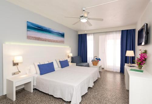 伊维萨镇皮提乌撒旅馆的白色卧室配有床和吊扇