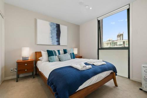 奥克兰Two Bedroom Apartment - Pool, Gym & Free Parking!的一间卧室设有一张大床和一个窗户。