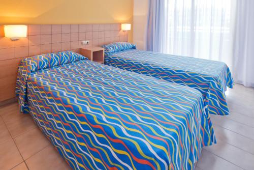 坎布里尔斯沃拉马尔坎布里尔斯公寓的酒店客房,配有两张带条纹床单的床