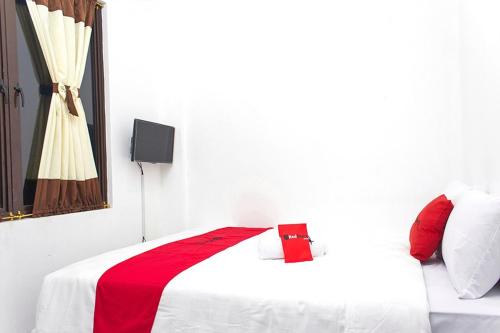 加拉旺RedDoorz @ Galuh Mas的白色客房,配有一张带红色毯子的床