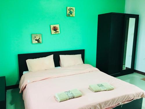 呵叻里奇霍姆汽车旅馆的绿色卧室配有一张带两个枕头的大床