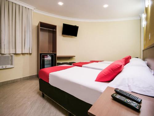 里约热内卢Hotel Villa Rica的酒店的客房 - 带红色和白色枕头的床
