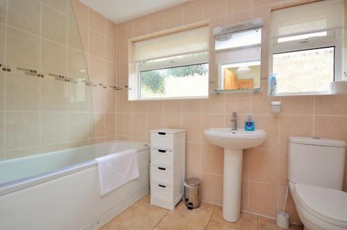 海景城Solent View的一间带水槽、浴缸和卫生间的浴室