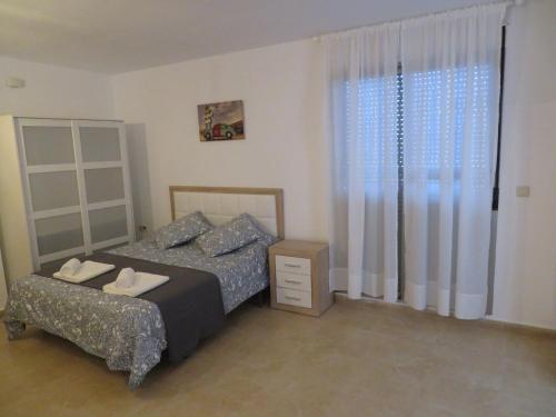 皮拉尔－德拉奥拉达达Apartamento Mil Palmeras的卧室配有床、椅子和窗户。