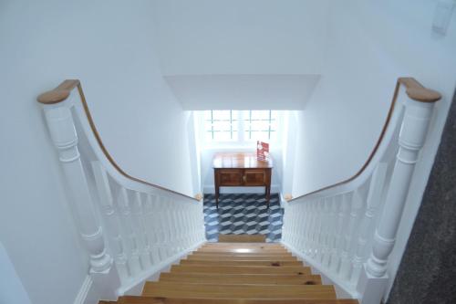 丰沙尔Heritage Apartments的楼梯通往带桌子的房间