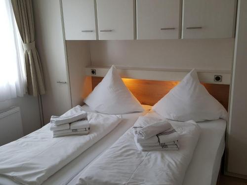 韦斯特兰Sylter-Besserburg-App-16的两张带白色床单和枕头的床