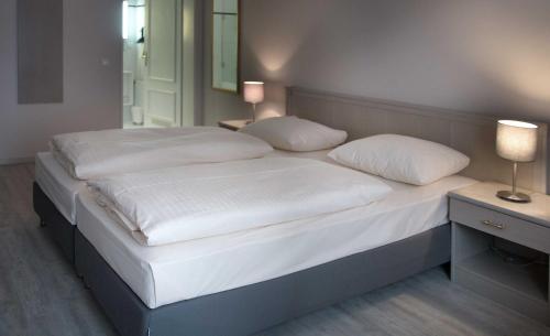 慕尼黑德意志剧院酒店的卧室内的一张带白色床单和枕头的床