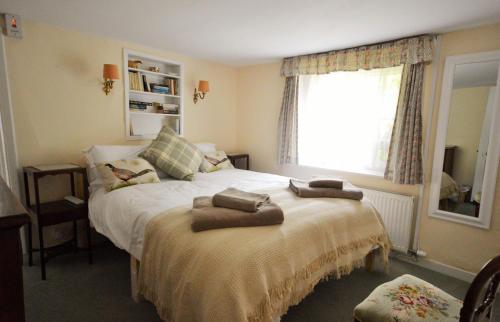 雅茅斯Grove Cottage的一间卧室配有一张床,上面有两条毛巾