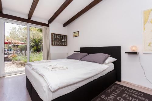 布尔扎克Molnar Resort Villa Mimoza & Apartment Nea的一间卧室设有一张大床和一个大窗户