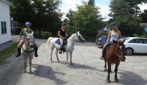 AndoverHighland Lake Inn的三位女孩在停车场骑马