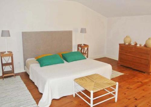 FronsacGarros的卧室配有带绿色枕头的大型白色床