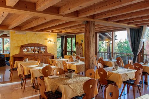 斯皮亚佐Casa Moresc的一间设有桌椅的餐厅,位于带窗户的房间内