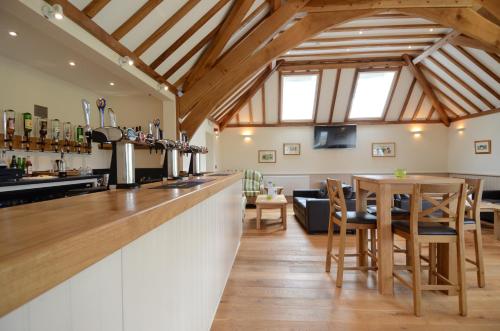 比尔斯韦尔斯Neuadd Henllan Lodge的厨房以及带吧台和桌子的客厅。