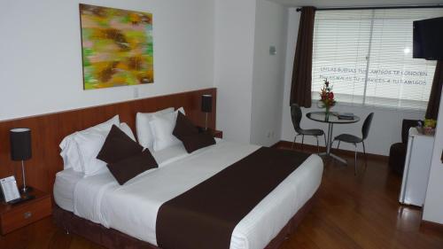 马尼萨莱斯加尔韦斯酒店的酒店客房设有一张大床和一张桌子。