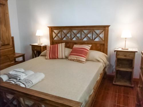 埃博森Alojamiento Las Retamas的一间卧室配有木床和2个床头柜