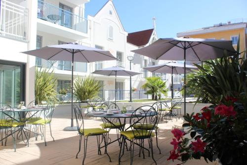 阿卡雄雷斯迪家阿卡松普拉扎酒店的一个带桌椅和遮阳伞的户外庭院。
