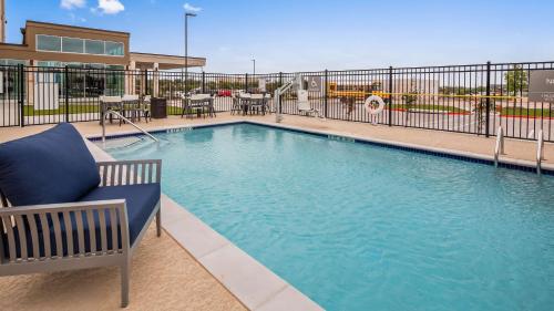 奥斯汀Best Western Plus Executive Residency Austin - Round Rock的一个带蓝椅的游泳池,靠近围栏