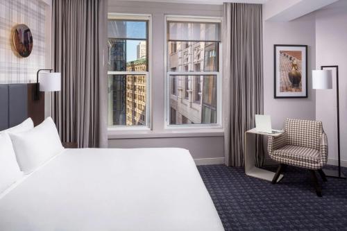 波士顿Hyatt Centric Faneuil Hall Boston的酒店的客房 - 带一张床、椅子和窗户