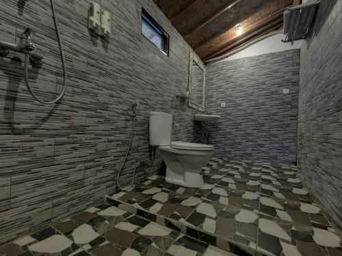 珀尼达岛Kamasan Cottage的一间带卫生间和砖墙的浴室