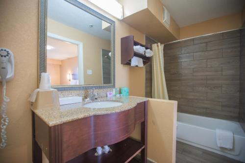 欧文欧文十字口酒店及套房的浴室配有盥洗盆、镜子和浴缸
