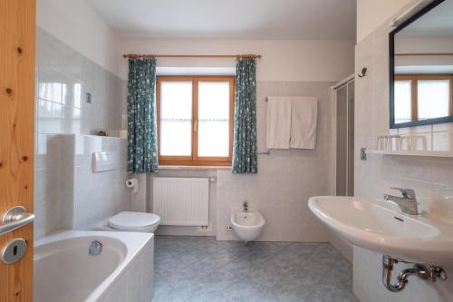 富内斯Mantingerhof的带浴缸、盥洗盆和卫生间的浴室