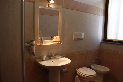 蒙蒂菲阿斯科尼拉康曼达公寓酒店的一间带水槽、卫生间和镜子的浴室