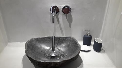 卡特瑞杜斯Maistrali Prive的浴室配有带水龙头的石质水槽。