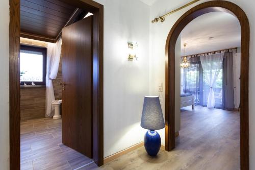 拜尔斯布龙Hotel Petra的走廊上设有镜子和蓝色花瓶