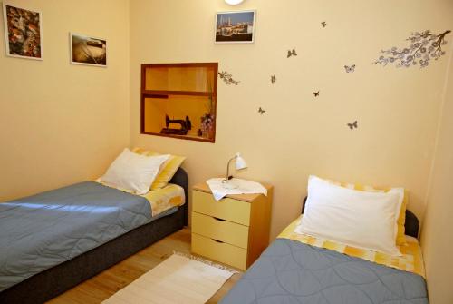 科米扎Apartment Tina的一间卧室配有两张床和一个带灯的床头柜