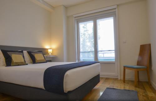 波尔图休达斑点公寓的一间卧室设有一张大床和一个窗户。