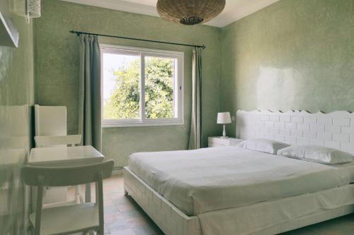 西迪考乌奇Blue Kaouki的一间卧室设有一张大床和一个窗户。