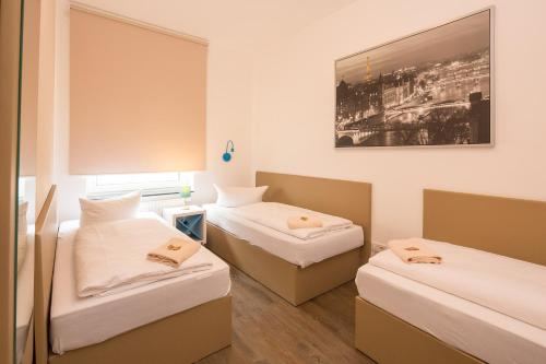 门兴格拉德巴赫T3城市阁楼公寓式酒店的一间设有两张床的客房,墙上挂着一张照片