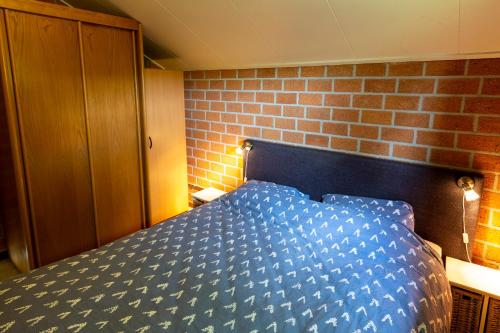 温特斯韦克科罗赛伯苓克度假屋的砖墙间一张蓝色的床