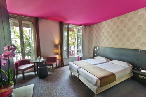 巴黎阿尔洛酒店的一间卧室设有一张粉红色天花板的大床