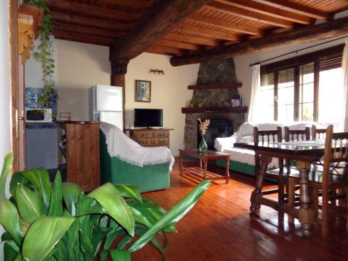 Villanueva del Conde巴图尔卡斯乡村小屋酒店的客厅配有桌子和壁炉