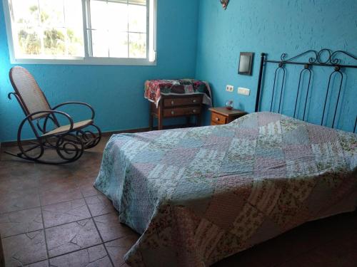 卡拉德莫尔Villa La Canarita的卧室配有床、椅子和窗户。