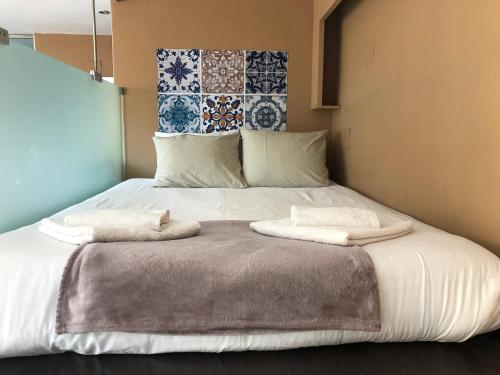 锡切斯Sitges Studio的一间卧室配有一张床,上面有两条毛巾
