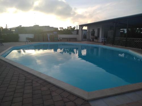 圣凯撒利亚温泉特拉瑟林纳酒店的一座大蓝色游泳池,位于房子前