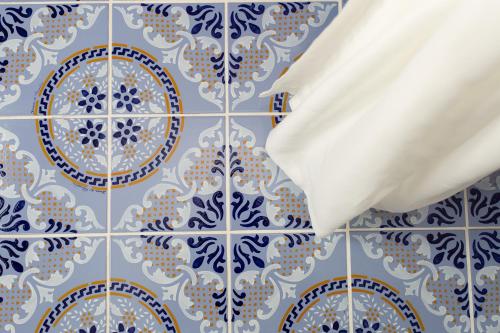 利帕里Odysseus Hotel的浴室的墙壁上铺有蓝色和白色的瓷砖