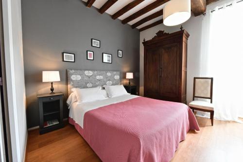 莫南Maison Canterou的一间卧室配有一张带粉色毯子的大床
