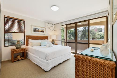 穆卢拉巴海滩港公寓的卧室配有白色的床和窗户。
