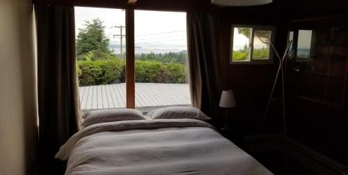 北温哥华City Gardens Suites B&B的一间卧室设有一张床和一个大窗户