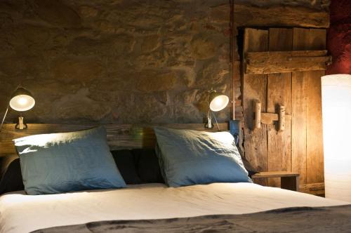 Sant Pere de TorellóCan Poca Roba的一间卧室配有带2个枕头和2盏灯的床