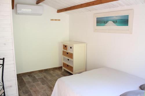 勒博塞Petit chalet climatisé avec jacuzzi privé的卧室配有白色的床和梳妆台。