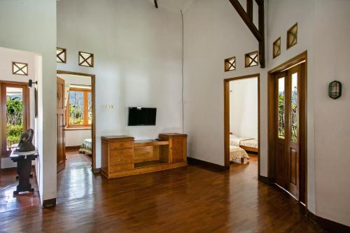 巴图香提度假屋的客厅配有木梳妆台上的电视