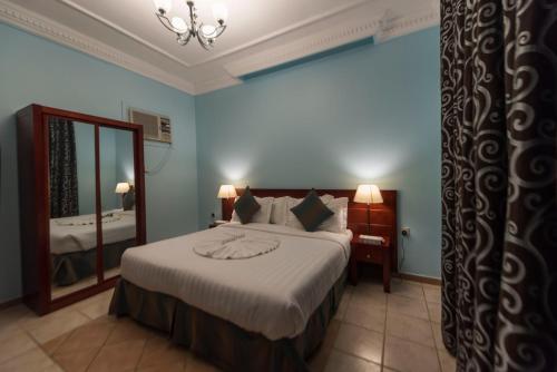 阿哈达Seven Gardens Pro的一间卧室配有一张大床和镜子