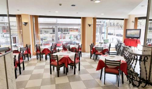 卡迪瓦维尼萨酒店的用餐室设有桌子和红色椅子以及窗户。