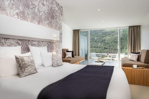 韦尔东河畔拉帕吕Hotel & Spa des Gorges du Verdon的一间卧室设有一张大床和大窗户