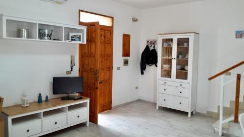 莱波拉诺Villa Peppino的客房设有电视和带橱柜的书桌。